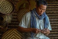 Seorang penenun di Desa Prailiu, Sumba Timur, sedang menata benang berbahan pewarna alami di teras rumah adat. Proses pembuatan tenun ikat tradisional ini membutuhkan waktu hingga berbulan-bulan demi menghasilkan mahakarya tekstil yang kaya akan filosofi.