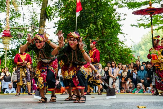 Seorang anak mendengarkan dongeng interaktif berbasis kebudayaan Nusantara yang dikemas segar melalui gawai tablet di sebuah perpustakaan modern.