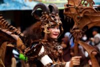 Seorang ilustrator muda sedang menyelesaikan karya seni digital yang mengadaptasi karakter mitologis Nusantara dengan sentuhan estetika kontemporer di studio kerjanya.