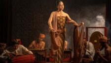 Seorang seniman visual menyelesaikan ilustrasi bertema cerita rakyat Nusantara yang memadukan teknik lukis tradisional dengan estetika desain grafis kontemporer.