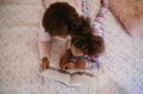 Seorang ibu membacakan buku cerita rakyat Nusantara kepada anaknya sebelum tidur di rumah. Tradisi lisan ini terbukti efektif mempererat ikatan emosional serta menumbuhkan imajinasi anak.