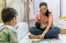 Seorang ibu membacakan buku cerita rakyat berilustrasi kepada anak-anaknya di kamar tidur untuk mempererat hubungan emosional sekaligus mengenalkan kekayaan budaya Nusantara sejak dini.