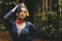 Seorang anak sedang menikmati buku cerita bergambar interaktif yang mengadaptasi kisah legenda Nusantara dengan ilustrasi berwarna tajam dan gaya visual modern.