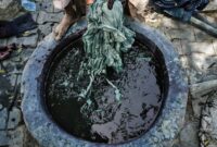 Seorang perempuan penenun tradisional di desa adat Sumba Timur sedang memintal benang kapas berbahan pewarna alami menggunakan alat tenun bambu khas nusantara.