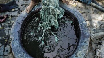 Seorang perempuan penenun tradisional di desa adat Sumba Timur sedang memintal benang kapas berbahan pewarna alami menggunakan alat tenun bambu khas nusantara.